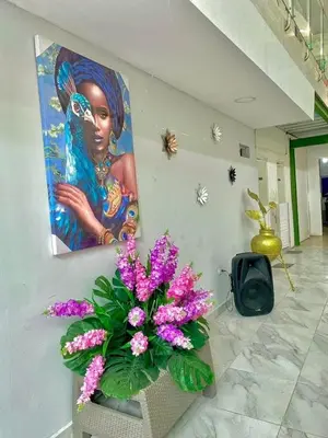 a painting of a woman on a wall with purple flowers at Habitación luxury villa oti in Ciénaga