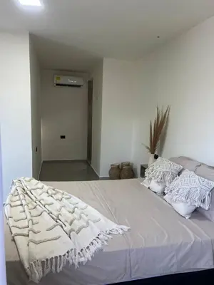 a white bed with a white blanket on top of it at Kiimala Villas y Hotel in Puerto Viejo