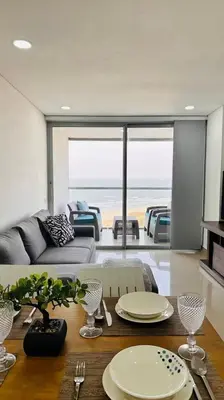 a living room with a table with plates on it at OD805 Acogedor Vista al Mar Piscina Vista Infinita in Cartagena de Indias