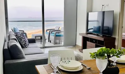 a living room with a couch and a television and a table at OD805 Acogedor Vista al Mar Piscina Vista Infinita in Cartagena de Indias