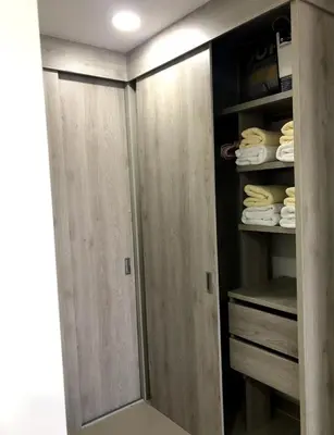 a walk in closet with wooden doors and towels at OD805 Acogedor Vista al Mar Piscina Vista Infinita in Cartagena de Indias