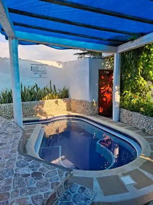 a swimming pool in the middle of a house at Cabañas Ana Sofía in San Antero