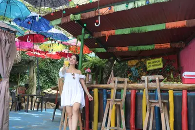 a woman in a white dress standing under umbrellas at Restaurante y Ecohostal Casa Loma in Chorrera