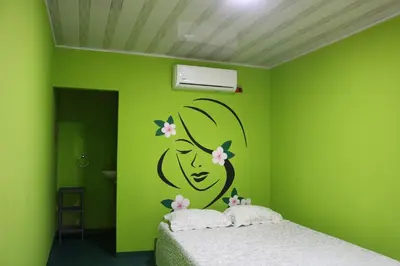 a green bedroom with a bed with flowers on the wall at Restaurante y Ecohostal Casa Loma in Chorrera