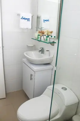 a white bathroom with a toilet and a sink at Ledymar Chalet in Cartagena de Indias