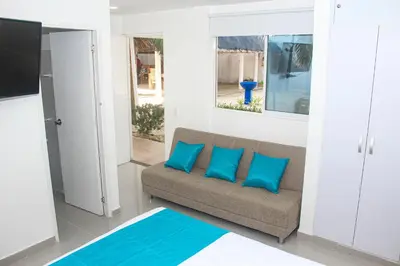 a living room with a couch and blue pillows at Ledymar Chalet in Cartagena de Indias