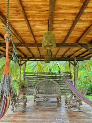 a porch with two hammocks and a wooden roof at Entre Palmas Cabañas in Moñitos