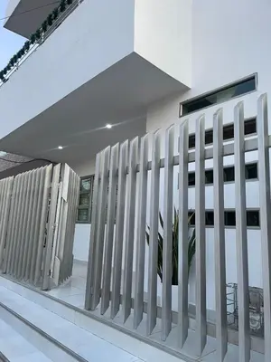 a white fence in front of a building at Apartamentos Mila in Guayabal