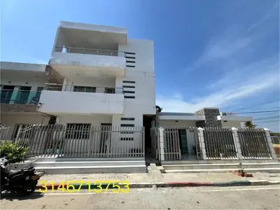 a white building with a fence in front of it at Apartamentos Mila in Guayabal