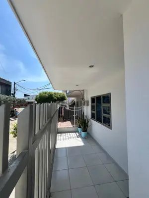 a white house with a fence and a walkway at Apartamentos Mila in Guayabal