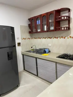 a kitchen with a sink and a black refrigerator at Apartamentos Mila in Guayabal