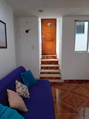 a living room with a blue couch and a wooden door at Apartamento Familiar para 6 personas in Cartagena de Indias