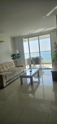 a living room with a couch and a glass table at Lujo frente a la playa in Cartagena de Indias