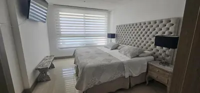 a bedroom with a large bed and a window at Lujo frente a la playa in Cartagena de Indias