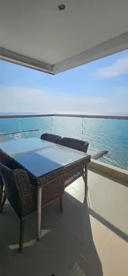 a table and chairs on the balcony of a cruise ship at Lujo frente a la playa in Cartagena de Indias