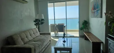 a living room with a couch and a table at Lujo frente a la playa in Cartagena de Indias