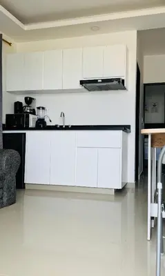 a white kitchen with white cabinets and a table at Apartamentos el mochilero frente a la playa piso 1 apto 2 in Cartagena de Indias