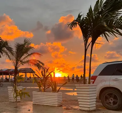 a car parked on a beach with a sunset at Apartamentos el mochilero frente a la playa piso 1 apto 2 in Cartagena de Indias