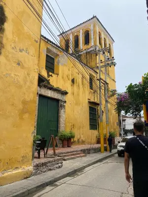 a yellow building with a green door on a street at Hospedaje Doña Argenida in Cartagena de Indias