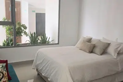 a white bed in a room with a window at Apartamento Boutique - Cartagena in Cartagena de Indias