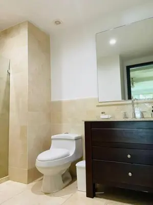 a bathroom with a toilet and a sink and a mirror at Modern Comfort - Spacious 2BR in Walled City in Cartagena de Indias