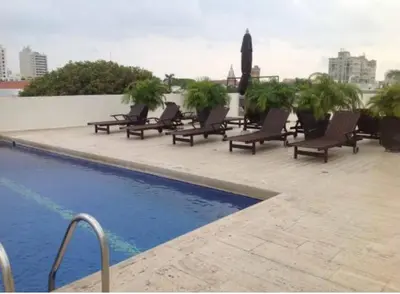a row of lounge chairs next to a swimming pool at Modern Comfort - Spacious 2BR in Walled City in Cartagena de Indias