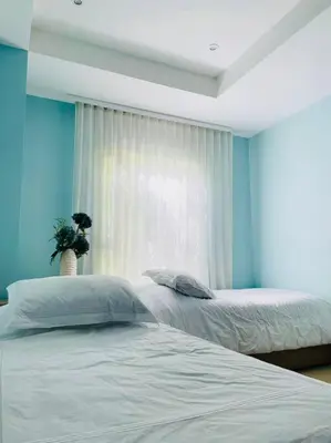 two beds in a bedroom with blue walls and a window at Modern Comfort - Spacious 2BR in Walled City in Cartagena de Indias