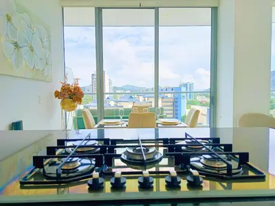 a kitchen with a stove and a table with a view at Apartamento VIP - Con vistas al Mar y Playa in Santa Marta