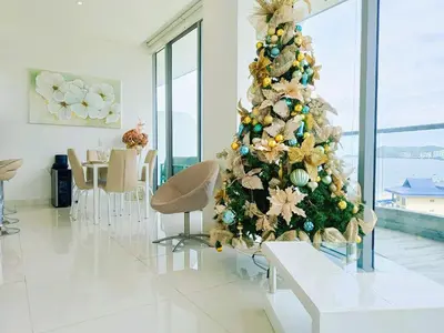 a christmas tree in a living room with a table and chairs at Apartamento VIP - Con vistas al Mar y Playa in Santa Marta