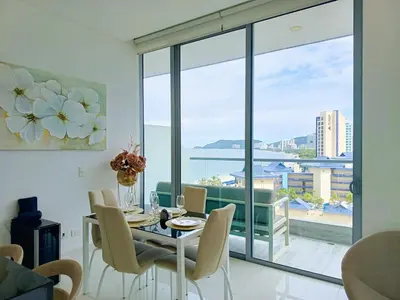 a dining room with a table and chairs and a large window at Apartamento VIP - Con vistas al Mar y Playa in Santa Marta