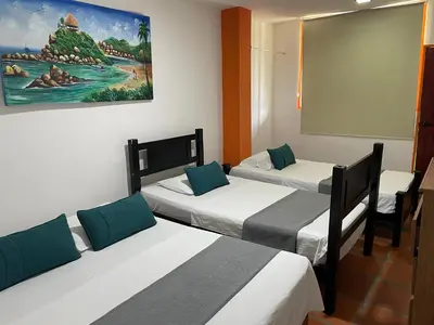 a room with three beds and a chalk board at Biohotel Caribe Green in Santa Marta