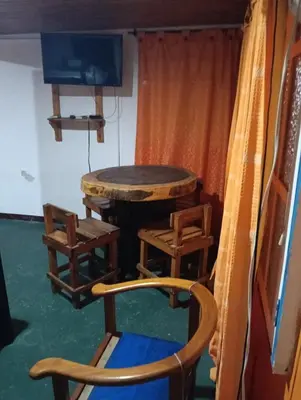 a table and chairs and a tv in a room at Biohotel Caribe Green in Santa Marta