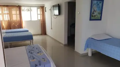 a room with two beds and a tv in it at Alojamiento Serena Tu Casa en la Playa in Cartagena de Indias