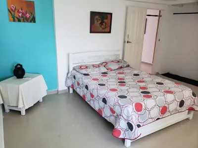 a bedroom with a bed and a table in it at Alojamiento Serena Tu Casa en la Playa in Cartagena de Indias