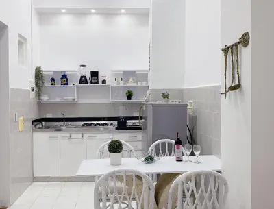 a white kitchen with a white table and chairs at Apartaestudio in Old City Cartagena apto 2C in Cartagena de Indias