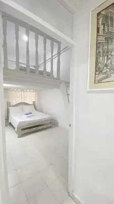 a white bedroom with a bed and a staircase at Apartaestudio in Old City Cartagena apto 2C in Cartagena de Indias