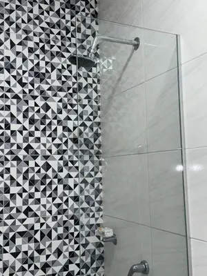 a bathroom with a shower with a black and white tiles at Rincón sereno barranquilla in Barranquilla