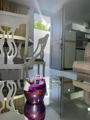 a living room with a vase on a glass table at Rincón sereno barranquilla in Barranquilla