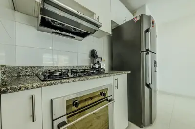 a kitchen with white cabinets and a stainless steel refrigerator at Edificio Morros 3, Beachfront & 2 Bedrooms by Inmobiliaria MFR in Cartagena de Indias