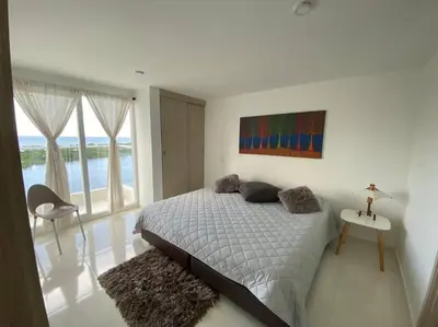 a bedroom with a bed and a view of the ocean at Mirador del Mar Playa Mendoza in Tubará
