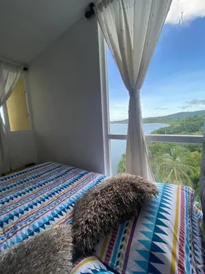 a bedroom with a bed and a large window at Mirador del Mar Playa Mendoza in Tubará