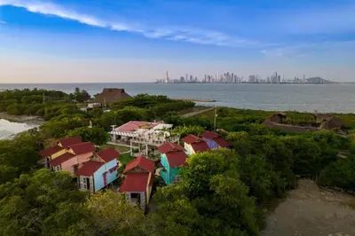 a group of houses with a city in the background at Tiny Village Cartagena Boutique Resort in Tierra Bomba