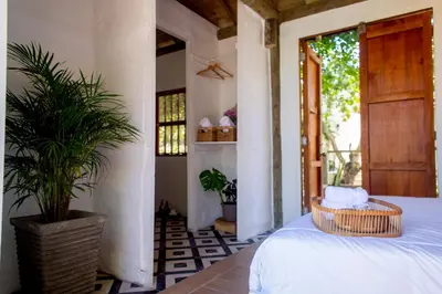 a bedroom with a bed and a plant in a room at Tiny Village Cartagena Boutique Resort in Tierra Bomba