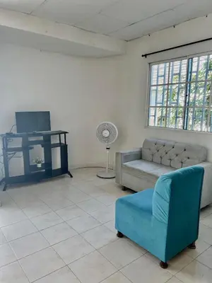 a living room with a couch and a fan at Apartamento hostal oasis in Puerto Colombia