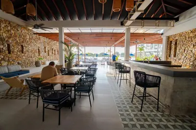 a restaurant with tables and chairs and a bar at Apartamento con laguna de aguas cristalinas in Cartagena de Indias