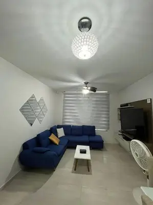 a living room with a blue couch and a table at Barranquilla Villa Campestre Malecon Rio Uninorte in Barranquilla