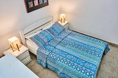 a bedroom with a bed with a blue blanket and two lamps at Ocean Luxe Morros in Cartagena de Indias