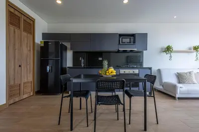 a kitchen with a black table and chairs and a couch at Cabrero Centro Tropical - Con vista al mar in Cartagena de Indias