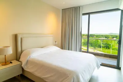 a bedroom with a white bed and a large window at Lujoso Apartamento Baia Kristal in Cartagena de Indias