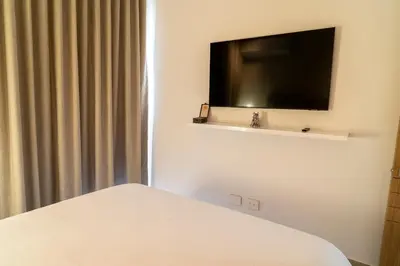 a bedroom with a bed and a flat screen tv at Lujoso Apartamento Baia Kristal in Cartagena de Indias